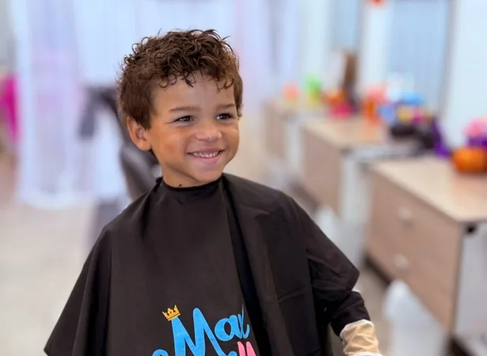 Curly-haired boy smiling after his haircut