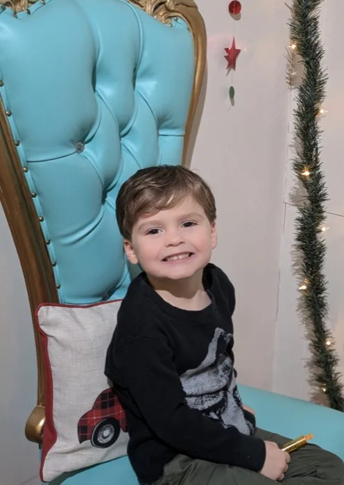 Little boy sitting in a blue throne chair