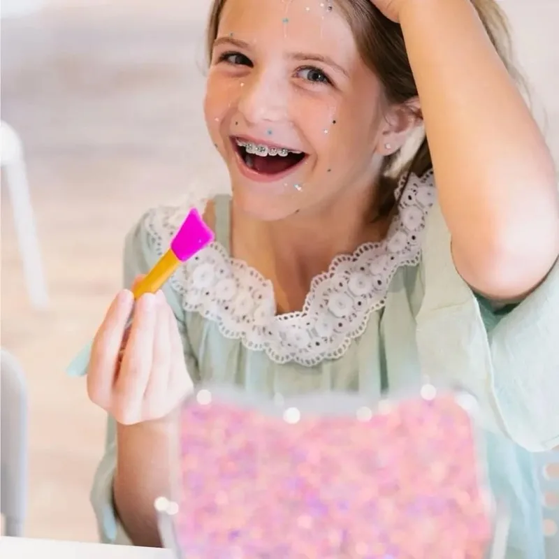 Girl enjoying a glitter face mask at a Max & Mia spa party